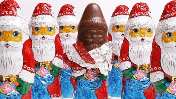 Sieben Schokoladen-Nikoläuse, von denen einer halb ausgepackt ist. © fotolia.com Foto: sk_design