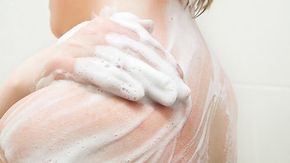 Rückenansicht einer duschenden Frau © fotolia.com Foto: gmstockstudio
