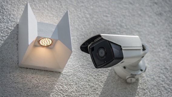 An einer Hauswand hängt neben eine Lampe eine Überwachungskamera © Picture Alliance / dpa Themendienst Foto: Daniel Maurer