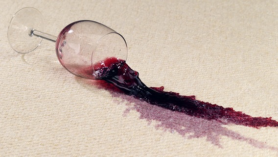 Ein volles Weinglas verschmutzt einen hellen Teppichboden © fotolia.com Foto: akf