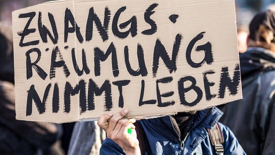 Eine Person hält ein Pappschild mit der Aufschrift "Zwangsräumung nimmt Leben" in der Hand. © Picture Alliance / dpa Foto: Florian Schuh