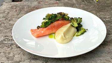 Arctic sea trout served with flower stalks and celery puree on a white plate.  © NDR 