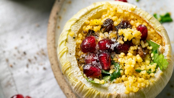 Kohlrabi baskets with couscous filling, pomegranate seeds and raisins served on a plate.  © NDR Photo: Zora Klipp