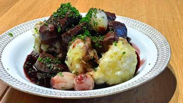 Reh-Ragout mit Thüringer Klößen auf einem weißen Teller serviert. © NDR 