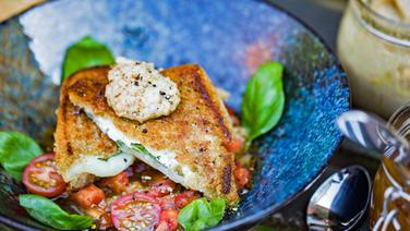 Crispy goat cheese sandwich on aubergine tomato chutney and nut pesto served on a plate.  © NDR Photo: Tarik Rose