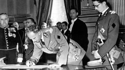König Leopold III. unterzeichnet am 16. Juli 1951 seine Abdankungsurkunde im Thronsaal des königlichen Schlosses in Brüssel. © dpa - Bildarchiv 