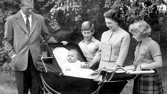 Balmoral Castle 1960: Prinz Philip, Prinz Charles, Queen Elizabeth und Prinzessin Anne stehen lächelnd um den Kinderwagen von Prinz Andrew herum © Picture-Alliance / dpa /  London Express 