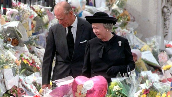 5. September 1997: Queen Elizabeth II. und Prinzgemahl Philip betrachten die Blumen und Geschenke für die verstorbene Diana vor dem Kensington Palace in London © Picture-Alliance / dpa 