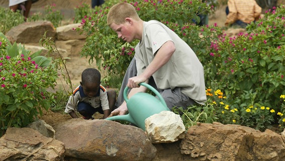 Prinz Harry pflanzt zusammen mit einem afrikanischen Kind aus Lesotho einen Baum ein © picture alliance / AP Photo Foto: Ben Curtis