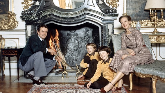 1980: Die dänische Königin Margrethe und Prinz Hendrik sitzen mit den beiden Söhnen Prinz Frederik (rechts) und Prinz Joachim vor einem Kamin © Picture-Alliance / dpa / Polfoto Foto: Elfeldt