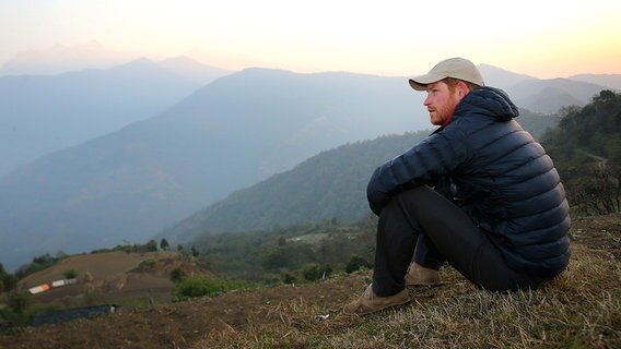 Bei seiner Nepalreise genießt Prinz Harry den Sonnenaufgang im Bergdorf Leorani. © Picture-Alliance /  Empics Foto: Chris Jackson