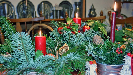 Tannengrün und Kerzenlicht schmücken jede Tafel weihnachtlich. © NDR / Medienkontor Foto: Iris Stark