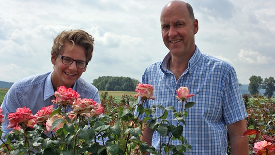 Zwei Männer stehen in einem Feld voller Freilandrosen. Zwei Männer stehen in einem Feld voller Freilandrosen. Foto: Isabell Hayn