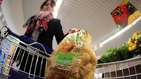 Eine Frau legt in einem Supermarkt von Aldi (Nord) Bio Kartoffeln in den Einkaufswagen © picture alliance / dpa Foto: Oliver Berg