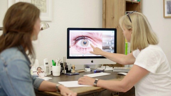 Zwei Frauen schauen sich ein Auge auf einem Monitor an. © NDR/Labo M GmbH 