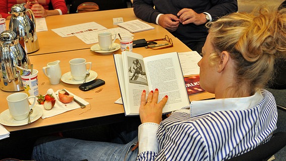 Barbara Schöneberger liest während der Redaktionskonferenz in einem Buch. © NDR/Uwe Ernst 