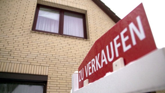 Vor einem Haus steht ein Schild "Zu verkaufen". © NDR 