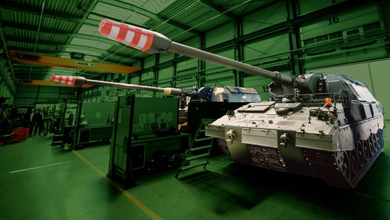 Zwei Panzerhaubitzen 2000 (PzH 2000) stehen in einer Produktionshalle von Rheinmetall. © picture alliance/dpa/Philipp Schulze | Look: Studio Fritz Gnad 