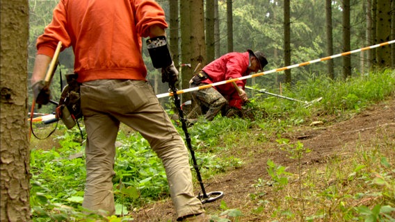 Grabungstechniker suchen den Boden mit Metalldetektoren ab. © Looks Film 