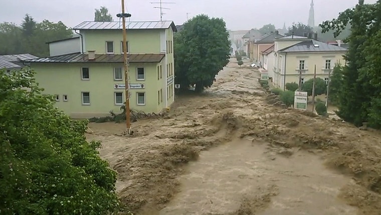 Blick von einer Brücke auf eine Straße, die zu einem reißenden Strom geworden ist. Sturzflut im bayerischen Ort Simbach im Sommer 2016. © NDR/SpiegelTV