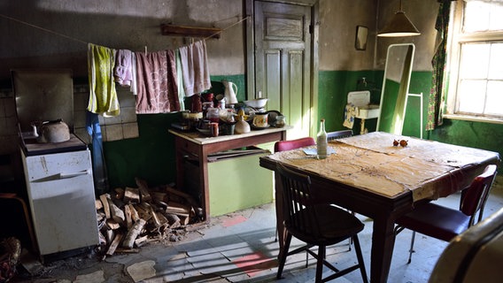 Eine alte Bauernküche mit Wäsche an der Leine über einem Herd. © NDR / Nicolas Maack 