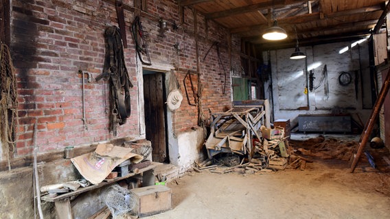 Stall mit alten Werkzeugen, die an der Wand hängen, und allerlei altes Gerümpel. © NDR / Nicolas Maack 