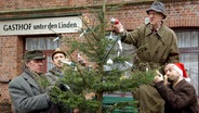 Szenenbild aus der 19. Büttenwarder-Folge "Weihnachten": Brackelmann, Adsche, Shorty und Kuno schmücken vor dem Dorfkrug den Tannenbaum. © NDR/Sandra Hoever Foto: Sandra Hoever