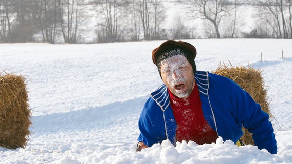 Szenenbild aus der 30. Büttenwarder-Folge "Der Ball rollt": Kuno ist mit dem Gesicht im Schnee gelandet. © NDR Foto: Sandra Hoever