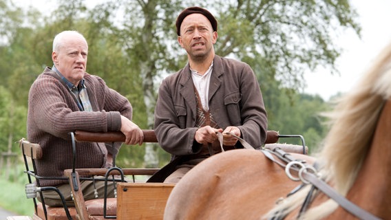 Szenenbild aus der 38. Büttenwarder-Folge "Erlentrillich": Kuno und Shorty fahren mit der Kutsche. © NDR/Nicolas Maack 