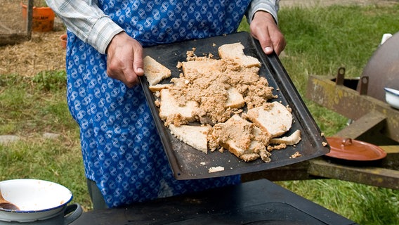 Szenenbild aus der 34. Büttenwarder-Folge "Guten Appetit": Ein Backblech mit mit Brotscheiben und Krümelkram. © NDR/Nicolas Maack 