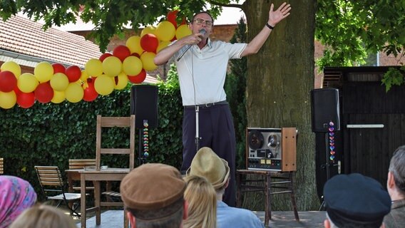 Der Besitzer des Frisiersalons "Erika Primatzki", Jürgen Seute, singt vor Publikum seinen Werbesong. © Polyphon / Uwe Ernst für NDR 