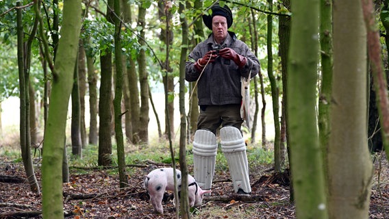 Ein Mann steht mit einem Schwein im Wald. © NDR/Nico Maack Foto: Nico Maack