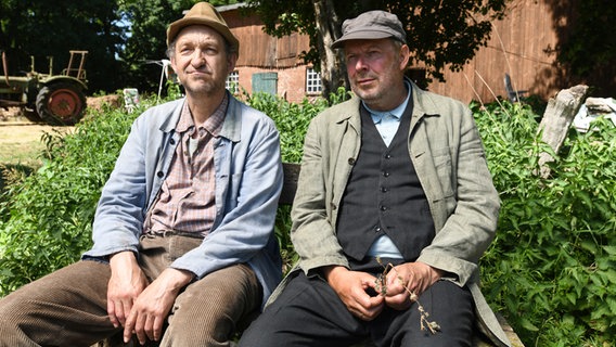 Adsche und Hajo sitzen auf einer Bank. © NDR/Uwe Ernst Foto: Uwe Ernst