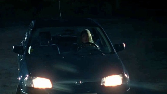 Szenenbild aus der 20. Büttenwarder-Folge "Silvester": Ein Auto mit Scheinwerferlicht. © NDR 