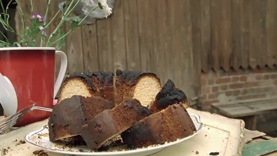 Szenenbild aus der 45. Büttenwarder-Folge "Kömkuchen": Der Büttenwarder-Kömkuchen steht zum Verzehr bereit. © NDR 
