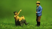 Mini-Brakelmann sitzt in der Wanne und schnackt mit Mini-Adsche. Szenen aus einem Animationsfilm mit Knetfiguren. © NDR 