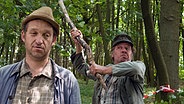 Brakelmann versucht Adsche im Wald am Tatort mit einem Knüppel eins überzubraten. © NDR/Nicolas Maack Foto: Nicolas Maack