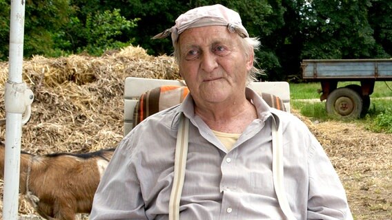 Szene aus der 18. Büttenwarder-Folge "Pflegeparadies": Onkel Krischan sitzt in einem Gartenstuhl. © NDR/Sandra Hoever Foto: Sandra Hoever