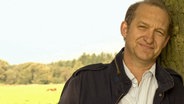 Neues aus Büttenwarder - Brakelmanns Freunde: Peter Heinrich Brix lehnt an einem Baum. © NDR 
