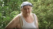 Szenenbild aus der 53. Büttenwarder-Folge "Sinn": Onkel Krischan im Unterhemd und mit Tuch auf dem Kopf. © NDR 
