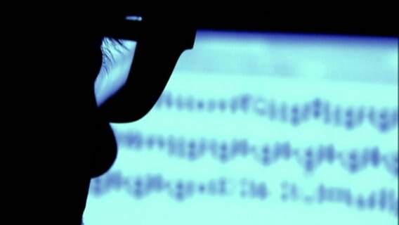 Die Silhouette eines Mannes mit Brille ist vor einem Bildschirm zu sehen. © NDR 