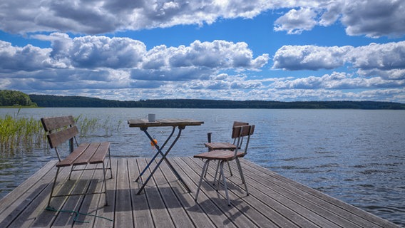 Steg mit zwei Stühlen, einer Bank und einem Tisch am Käbelicksee bei Dalmsdorf. © NDR Foto: Andreas Krippner aus Mirow