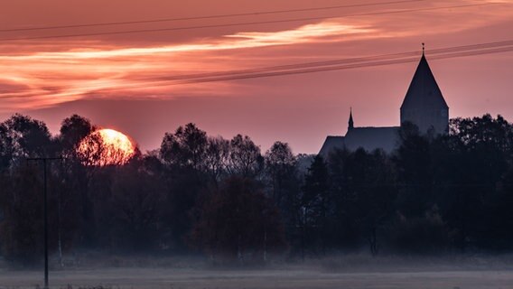 Sonnenaufgang über der Silhouette einer Stadt © NDR Foto: Frank Liedtke aus Leyerhof