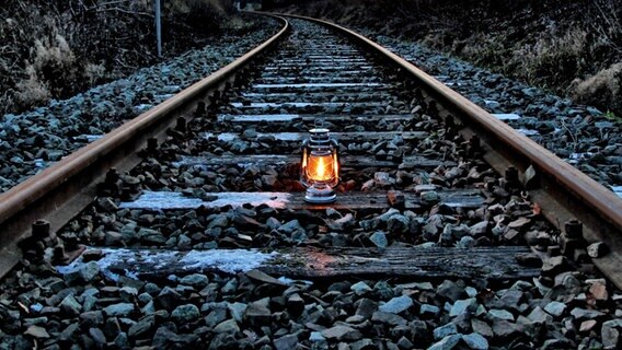 Leuchtende Lampe steht auf einem Gleisbett. © NDR Foto: Eckhard Wolfram aus Salow