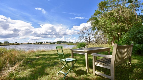 Stühle und eine Bank stehen vor einem See. © NDR Foto: Robert Gerber aus Greifswald