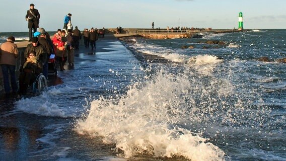 Eine hohe Welle erschreckt einige Spaziergänger auf der Westmole. © NDR Foto: Ingrid Strauß aus Grevesmühlen