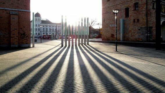 Stelen symbolisieren die Rostocker Stadtmauer im Gegenlicht. © NDR Foto: Helmut Kuzina aus Wismar