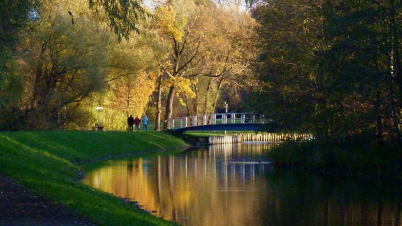 Spaziergänger im Park vor einer Brücke © NDR Foto: Joachim Grimm aus Karlshagen