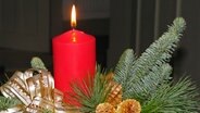 Adventsgesteck mit entzündeter Kerze © NDR Foto: Karin Mußfeldt aus Woosten (Goldberg)