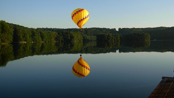 Ein Heißluftballon spiegelt sich im Feldberger Haussee. © NDR Foto: Lothar Klauß aus Wittenberg